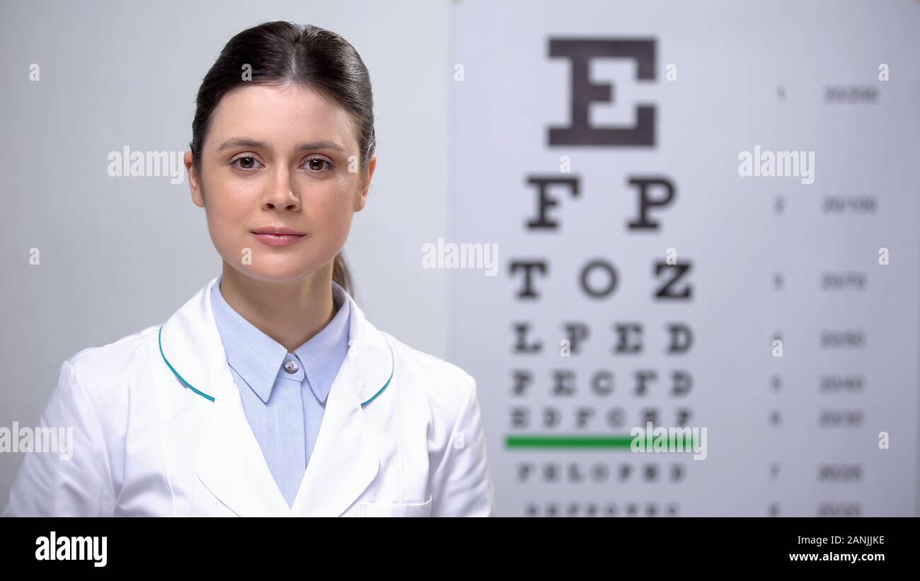 Femmina professionale oculista guardando la telecamera contro eye-sfondo grafico Foto Stock