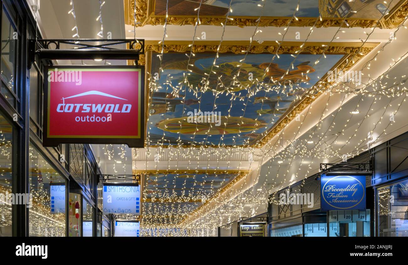 Cartello pensile per il negozio all'aperto Cotswold e le luci di Natale a Piccadilly Arcade, New Street, Birmingham, West Midlands, Inghilterra, Regno Unito Foto Stock