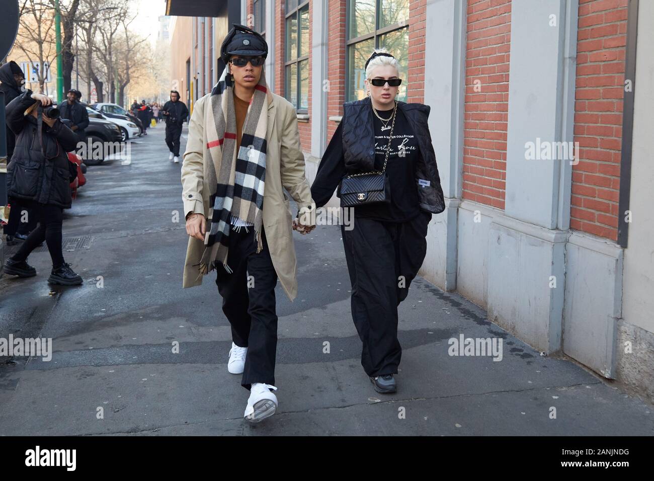 Milano, Italia - 13 gennaio 2019: l'uomo con rivestimento di colore beige e donna con nero borsa Chanel a piedi prima di Fendi fashion show, la Settimana della Moda Milanese street styl Foto Stock