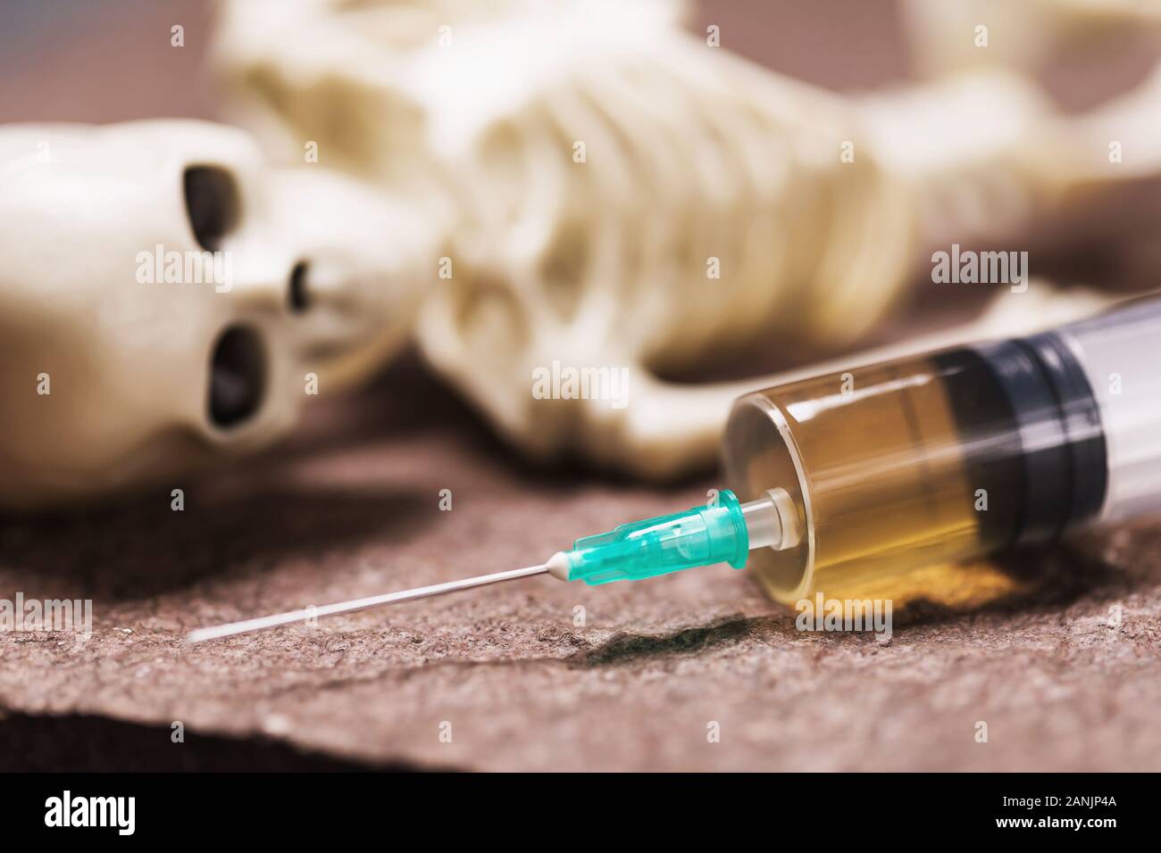 Siringa e scheletro umano su una pietra. Iniezione Letale concept Foto Stock