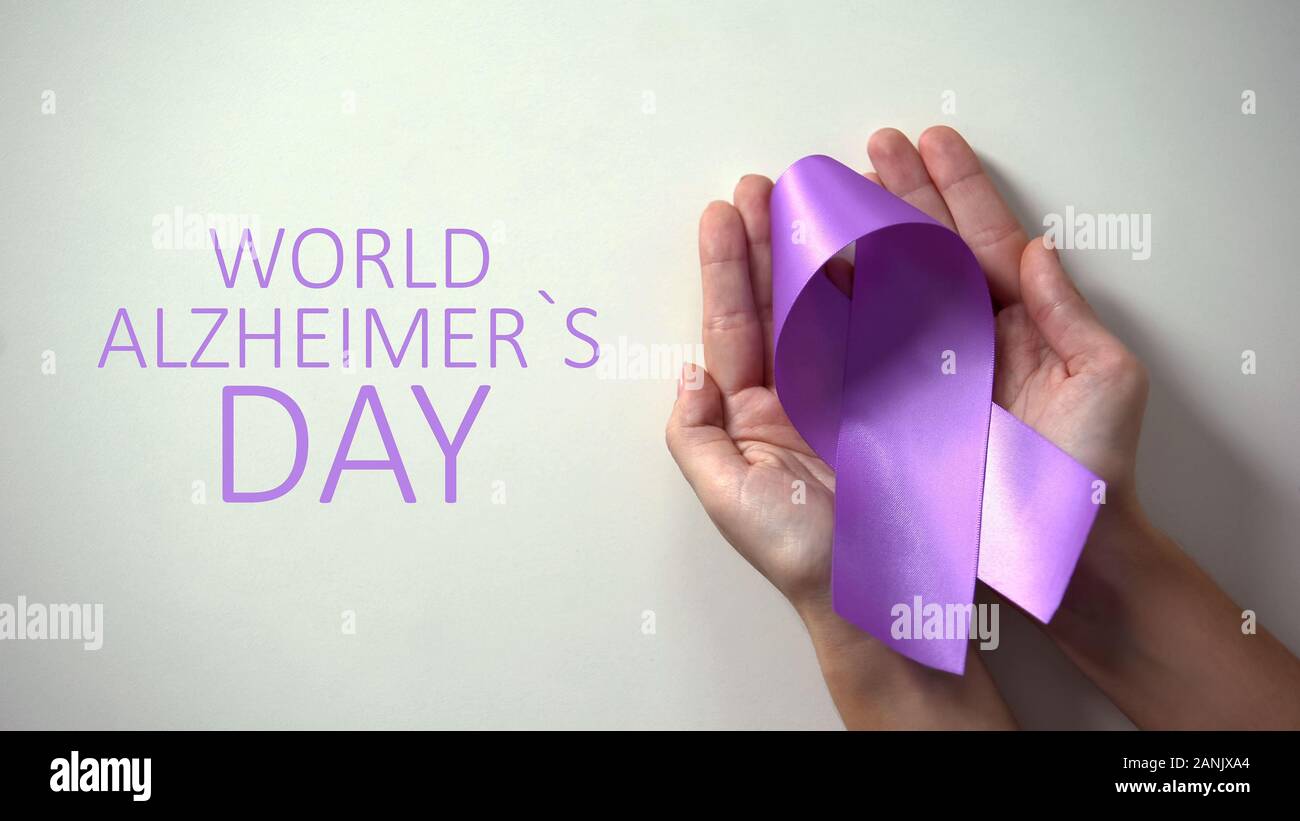 Il morbo di Alzheimer mondo giorno iscrizione, persona in possesso di nastro viola la consapevolezza della malattia Foto Stock