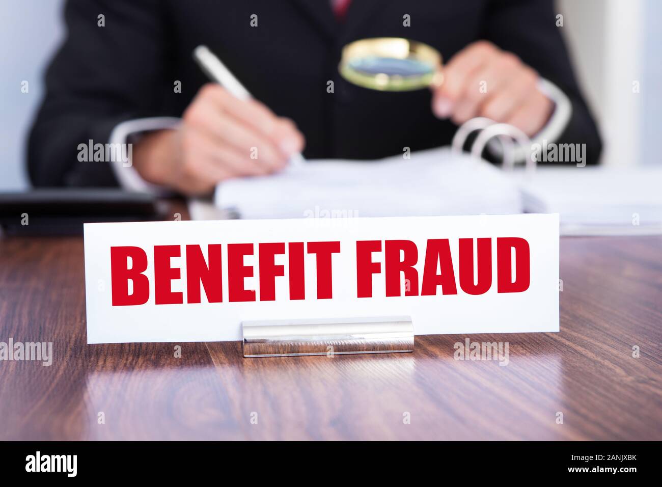 Close-up di una targhetta con vantaggio la frode titolo dell'uomo con il controllo dei documenti utilizzando la lente di ingrandimento Foto Stock
