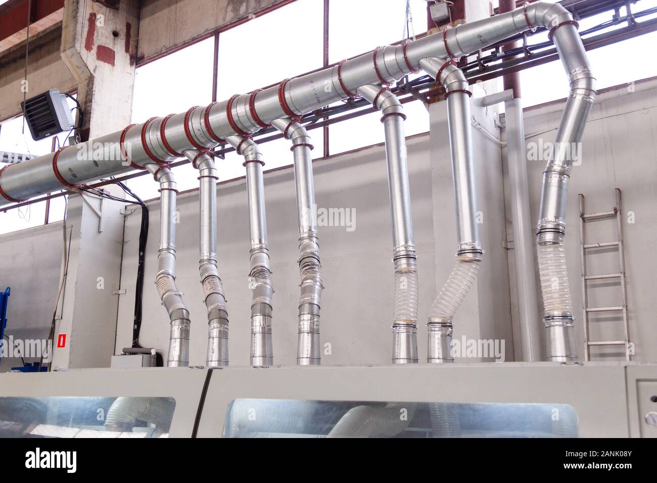 Condotti e tubi di un industriale sistema di aspirazione in corrispondenza di una falegnameria e segheria fabbrica. Foto Stock