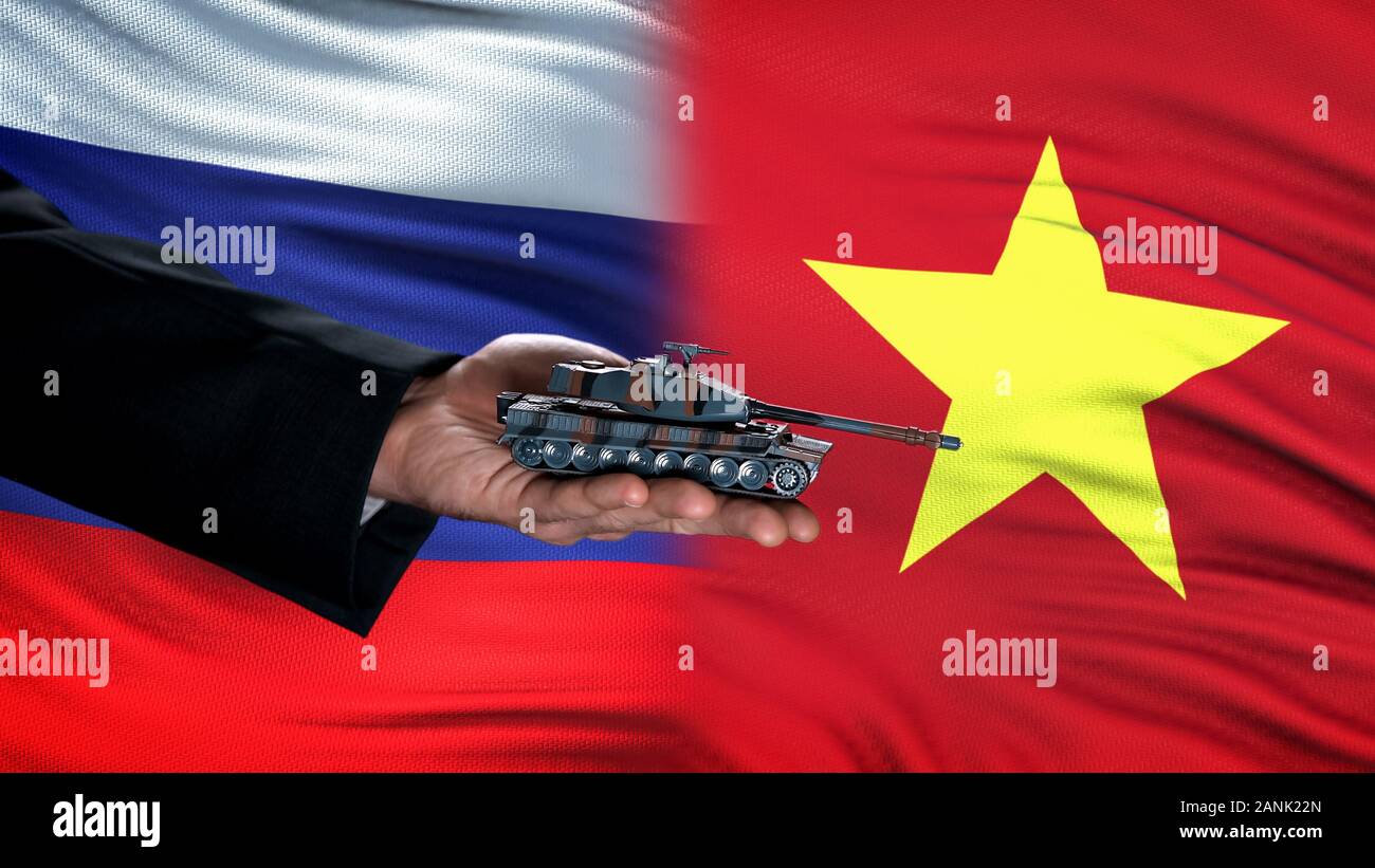 Gazzetta mano azienda toy serbatoio contro la Russia e il Vietnam bandiera, bracci globale Foto Stock