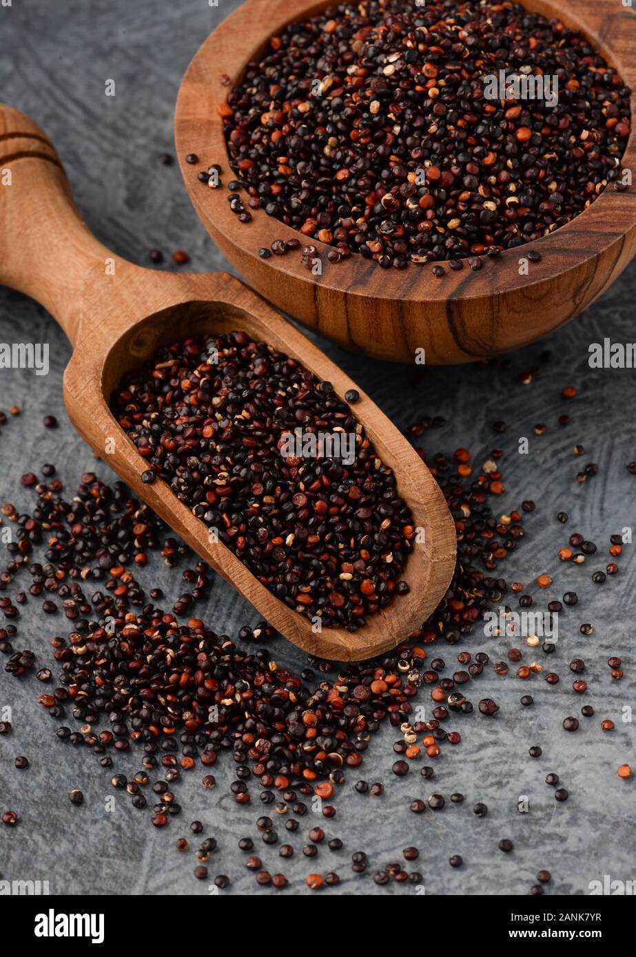 Chiusura del cucchiaio di legno e ciotola con nero semi di quinoa Foto Stock