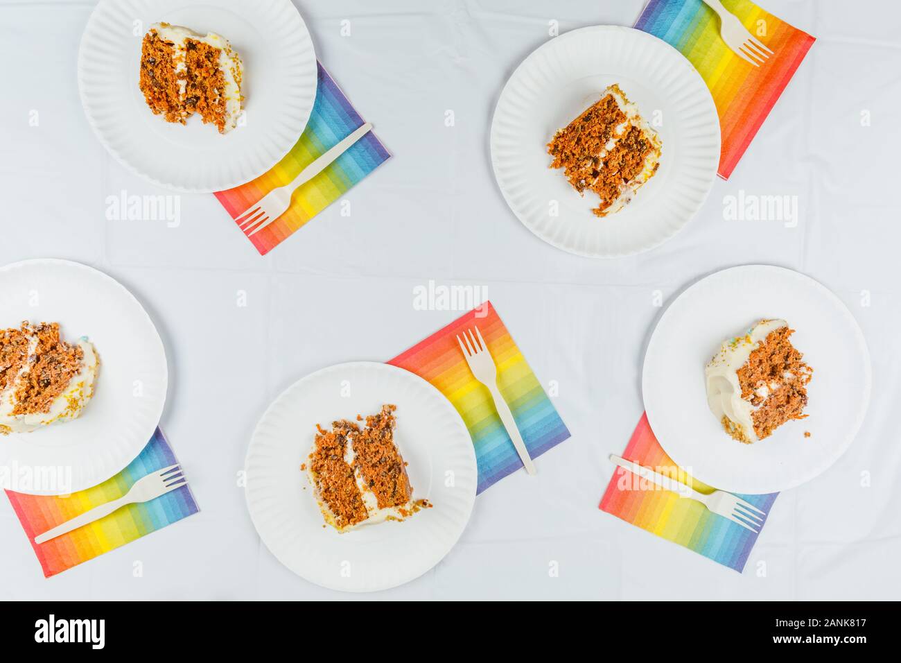 Lay piatto con la torta di compleanno di pezzi sul libro bianco le piastre. Festa di compleanno celebrazione del concetto. Posizione orizzontale Foto Stock