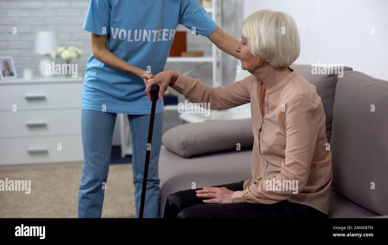 Tipo di Volontariato Ospedaliero aiutando pensionato disabili con un bastone, altruismo Foto Stock