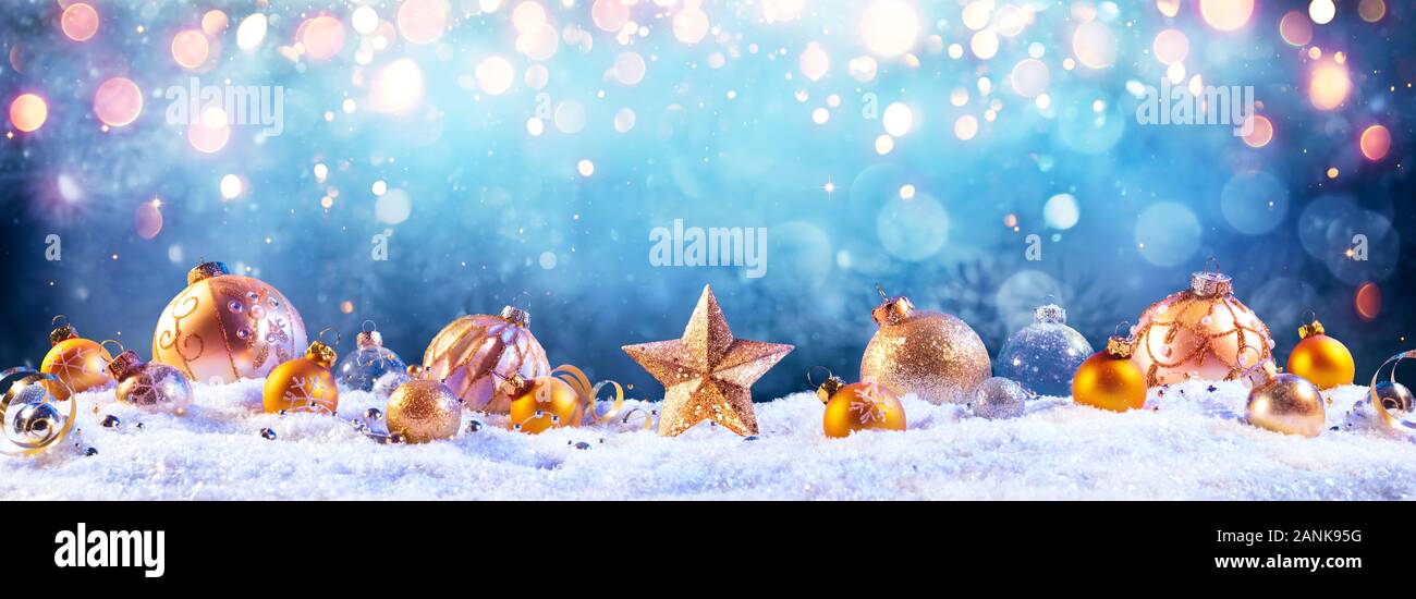 Golden Baubles Sulla Neve Con Luci Di Natale Foto Stock