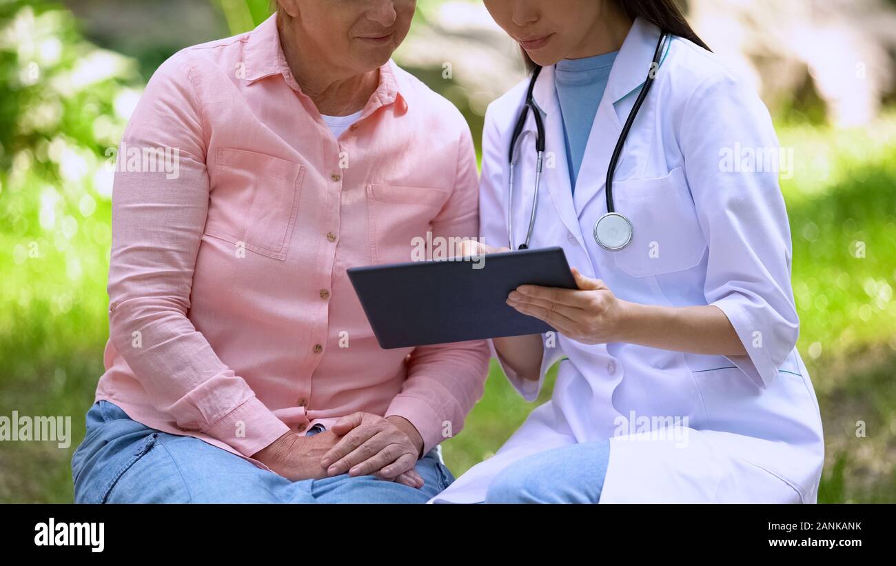 Giovane medico che mostra le immagini su tablet discutendo la diagnosi di età paziente femmina Foto Stock