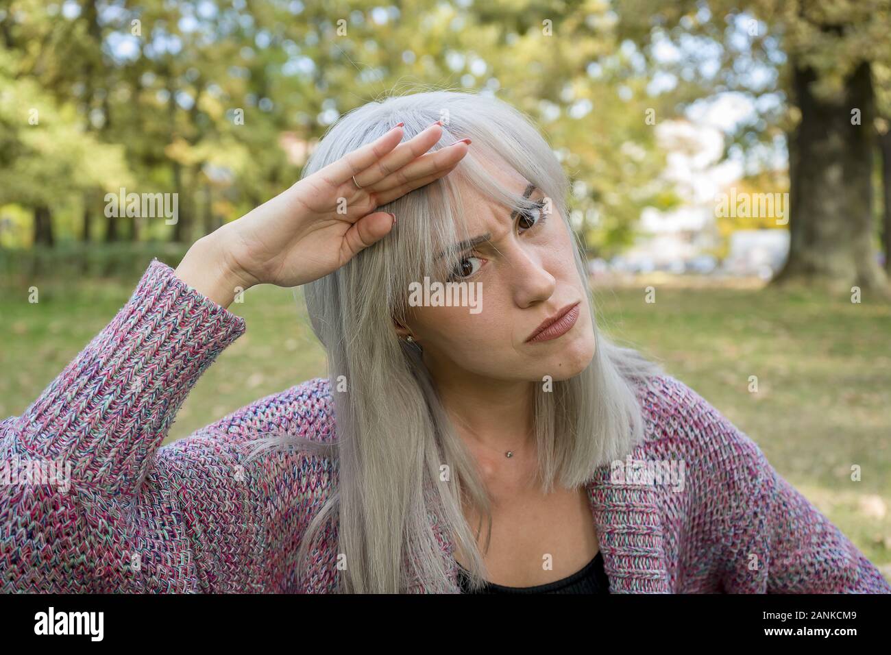 Ritratto all'aperto di una donna che fa volti divertenti. Capelli d'argento. Foto Stock