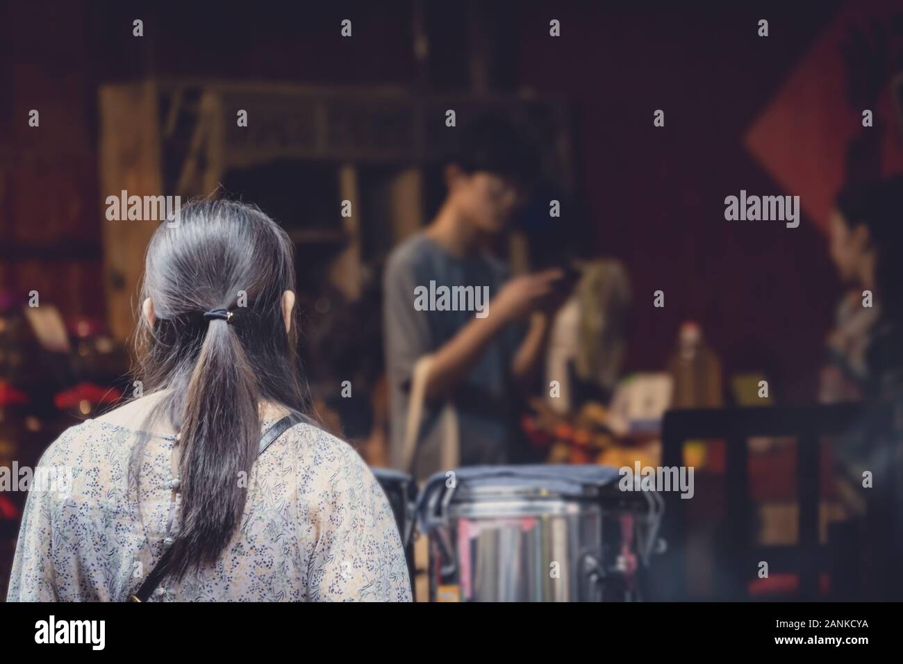 Feng Huang, Cina - Agosto 2019 : i vecchi donna cinese code alla parte anteriore della strada locale fornitore di prodotti alimentari in attesa per il suo ordinato il fast food snack per essere s Foto Stock