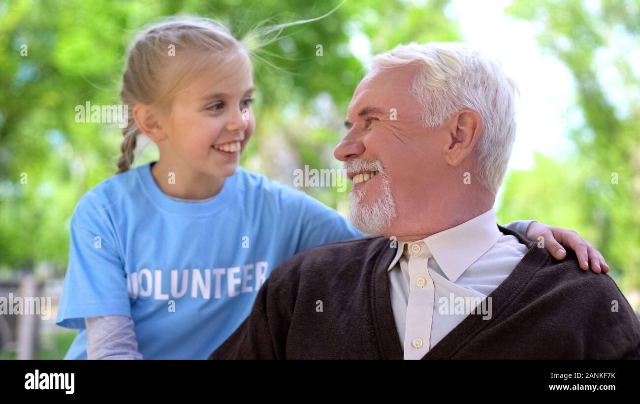 Bambino Felice costeggiata di volontariato pensionato maschio sorridente ogni altra vecchia cura di persone Foto Stock