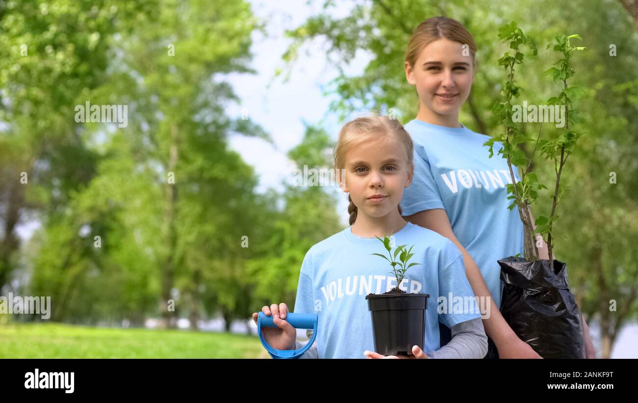 Piccola Ragazza donna giovane e struttura di contenimento alberelli, eco progetto di volontariato Foto Stock