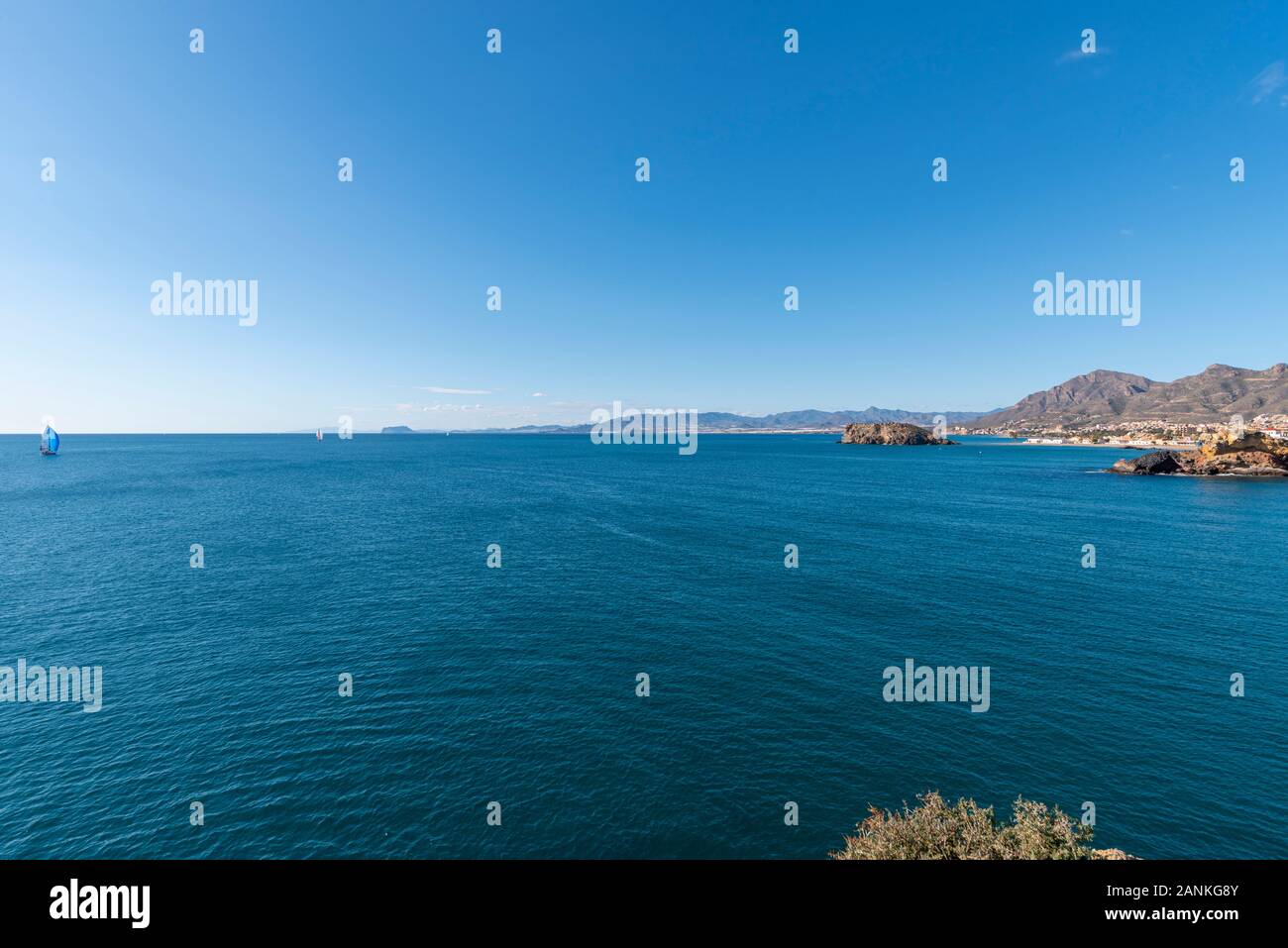 Playa de La Reya bay in Puerto de Mazarron, Murcia, Costa Calida, Spagna UE. Acque blu del mar Mediterraneo su un luminoso cielo blu al giorno. In barca a vela Foto Stock