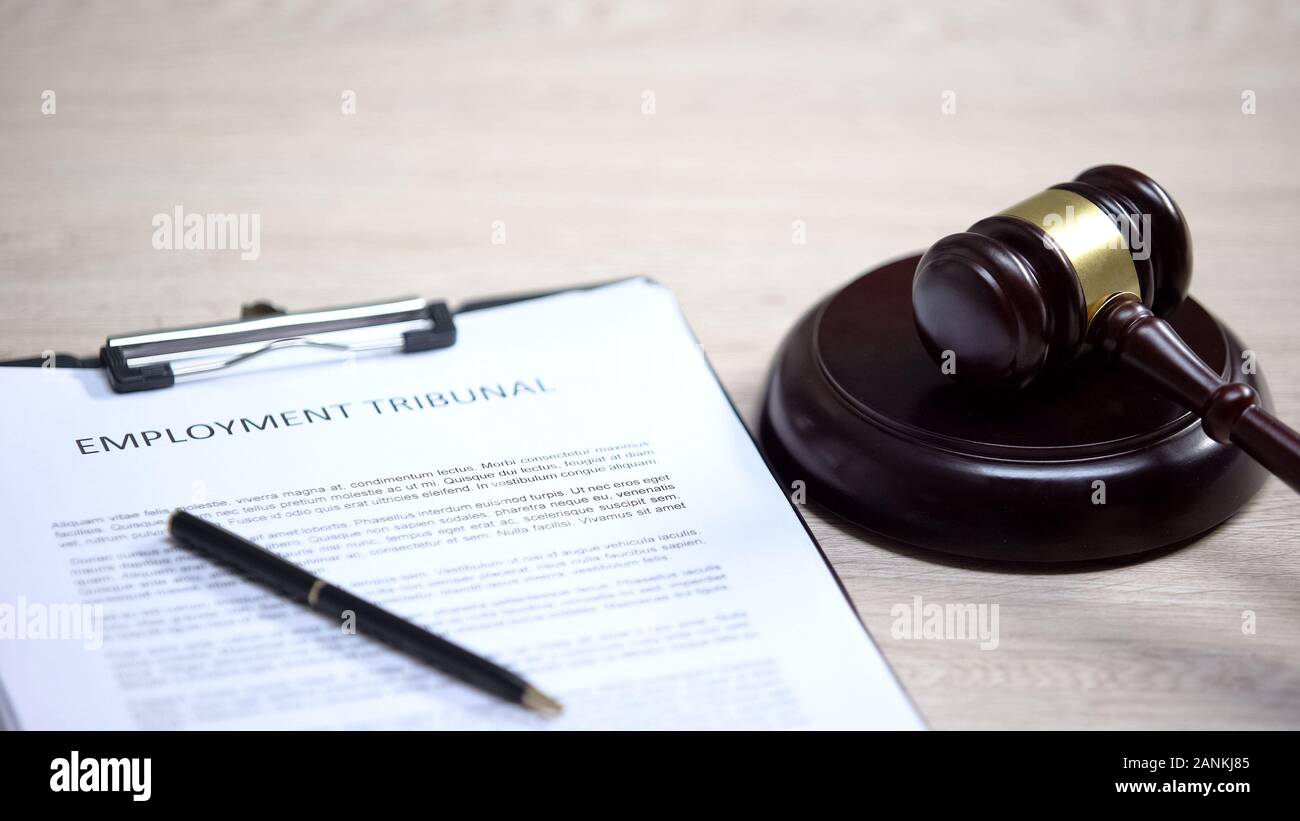 Employment Tribunal documento sul tavolo, martello giacente sul blocco audio, controversia Foto Stock