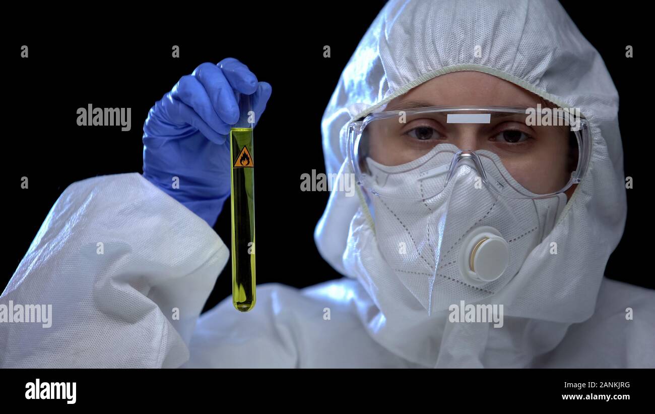 Lavoratore di carburante illegale lab tenendo in mano il tubo di prova con additivi infiammabili Foto Stock