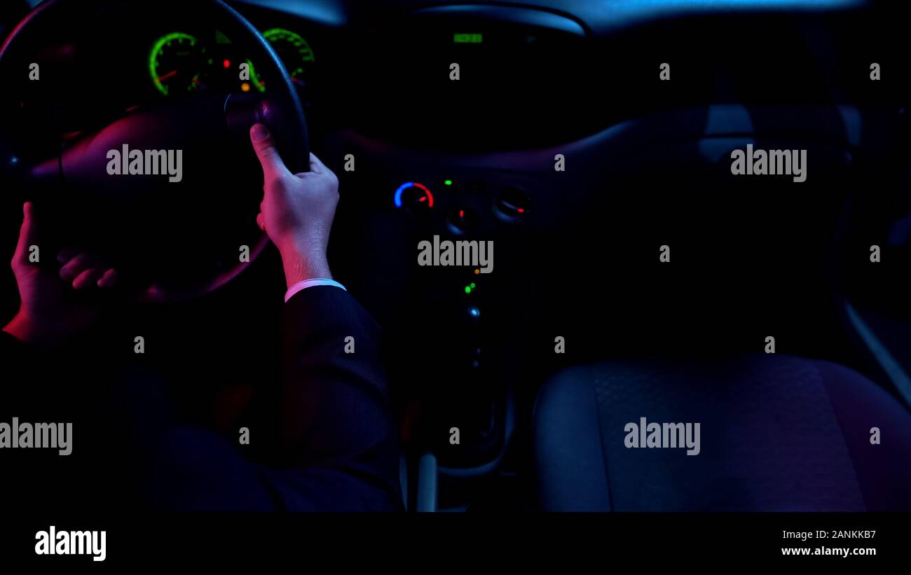 Uomo alla guida di auto da soli la notte, round-the-clock di servizio taxi, auto interno Foto Stock