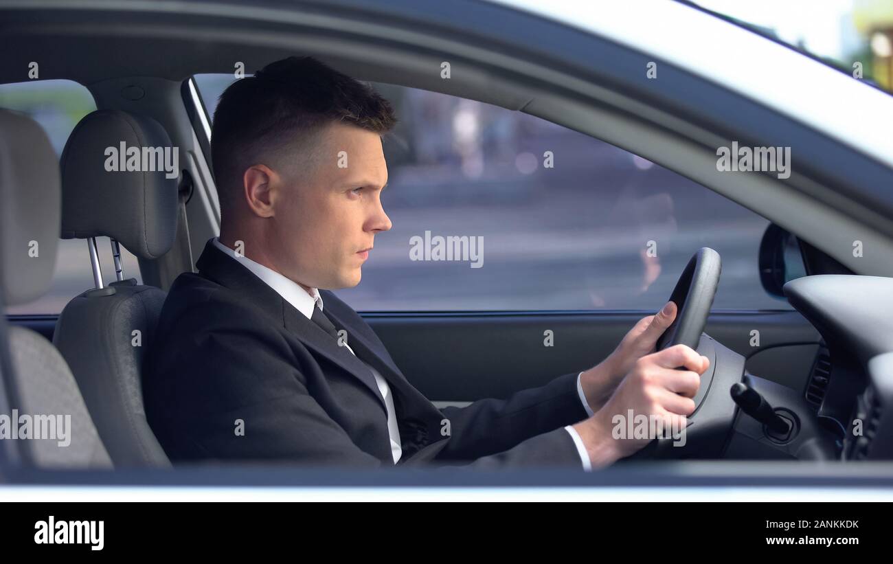 Orinato maschio in abito formale seduti sul sedile di guida, vita stressante, sovraffaticamento Foto Stock