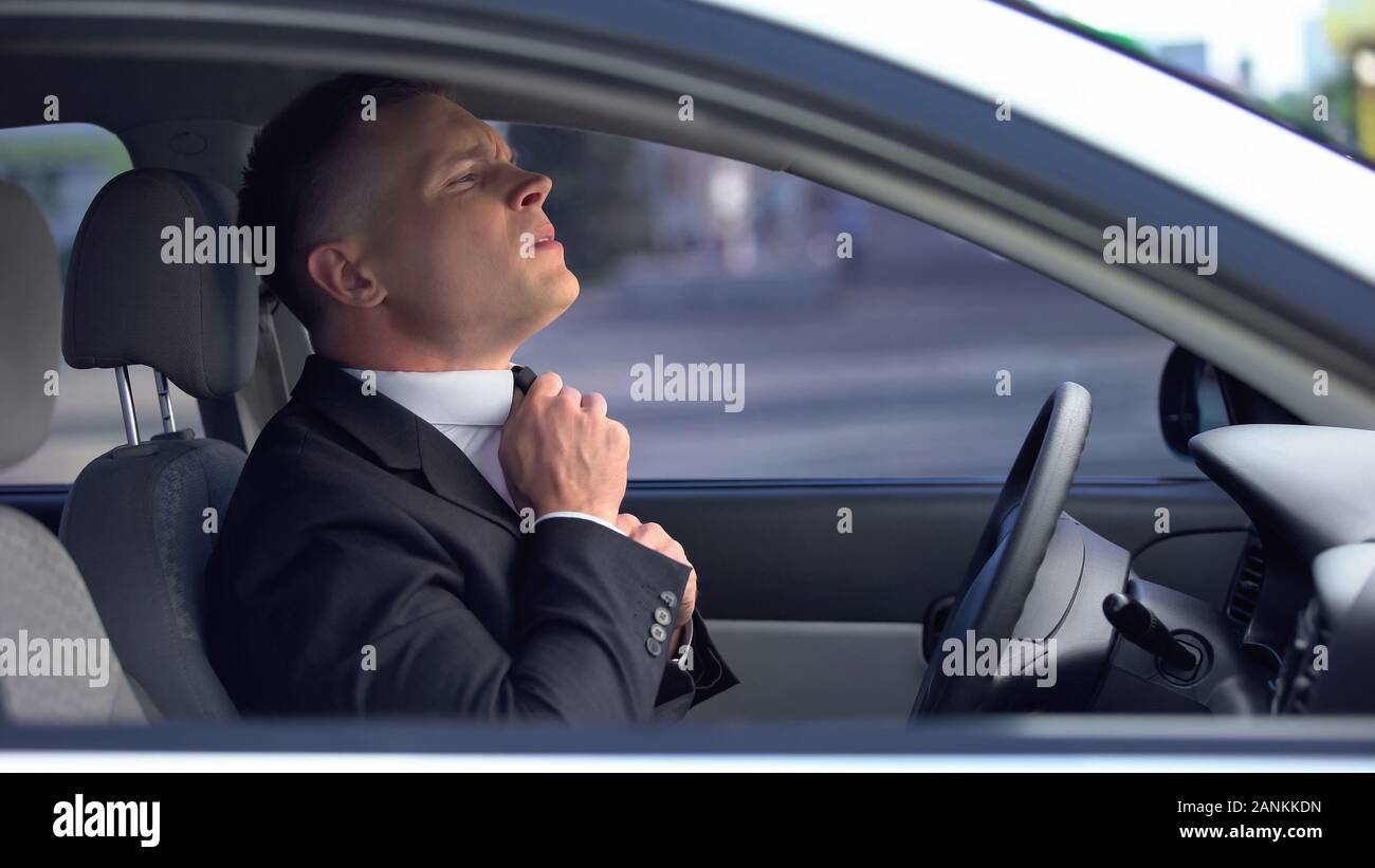 Ansiosi uomo tirante di regolazione in auto preoccupato prima di importante incontro, il colloquio di lavoro Foto Stock