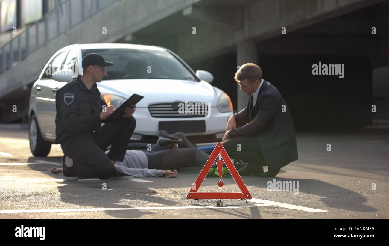 Segno di emergenza su strada, poliziotto la scrittura di report, collisione auto con noleggio biciclette Foto Stock