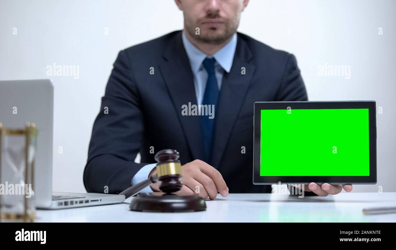 Fiducioso avvocato in possesso di tablet con schermo verde, avvocato di assistenza online Foto Stock