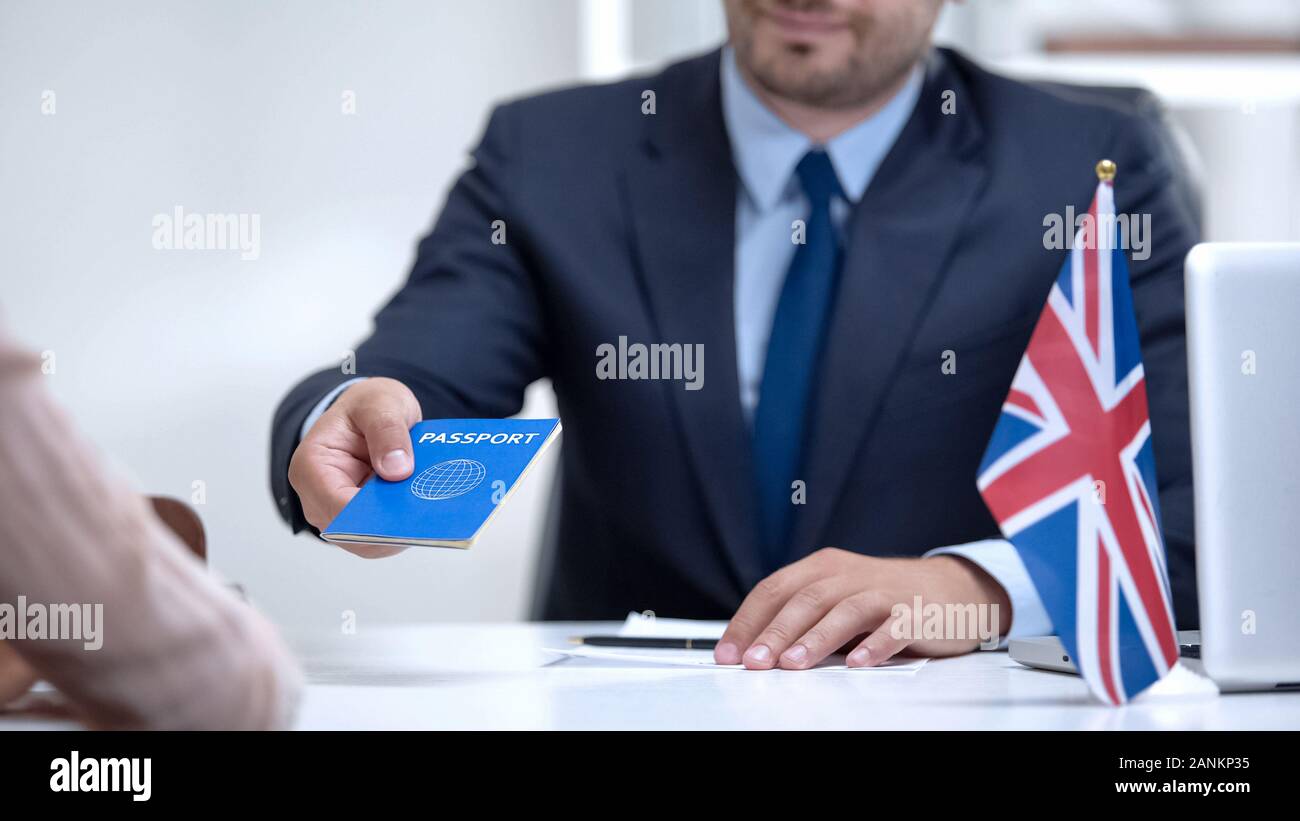 Ambasciata britannica officer dando passaporto per l'immigrato, Student Visa approvazione Foto Stock