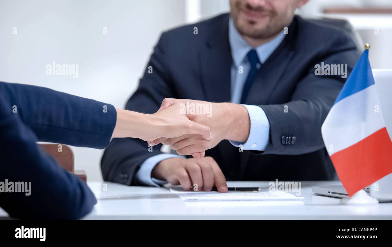 Il francese firma ufficiale docs circa lo stato di supporto business, agitando la mano del partner Foto Stock