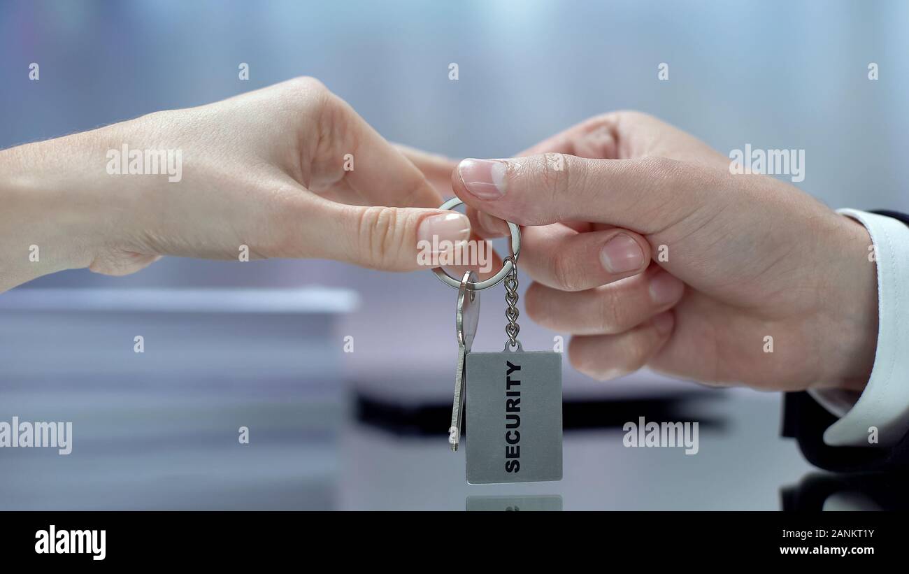 Mano dando chiavi femmina per top secret informazioni, fornire servizi di sicurezza Foto Stock