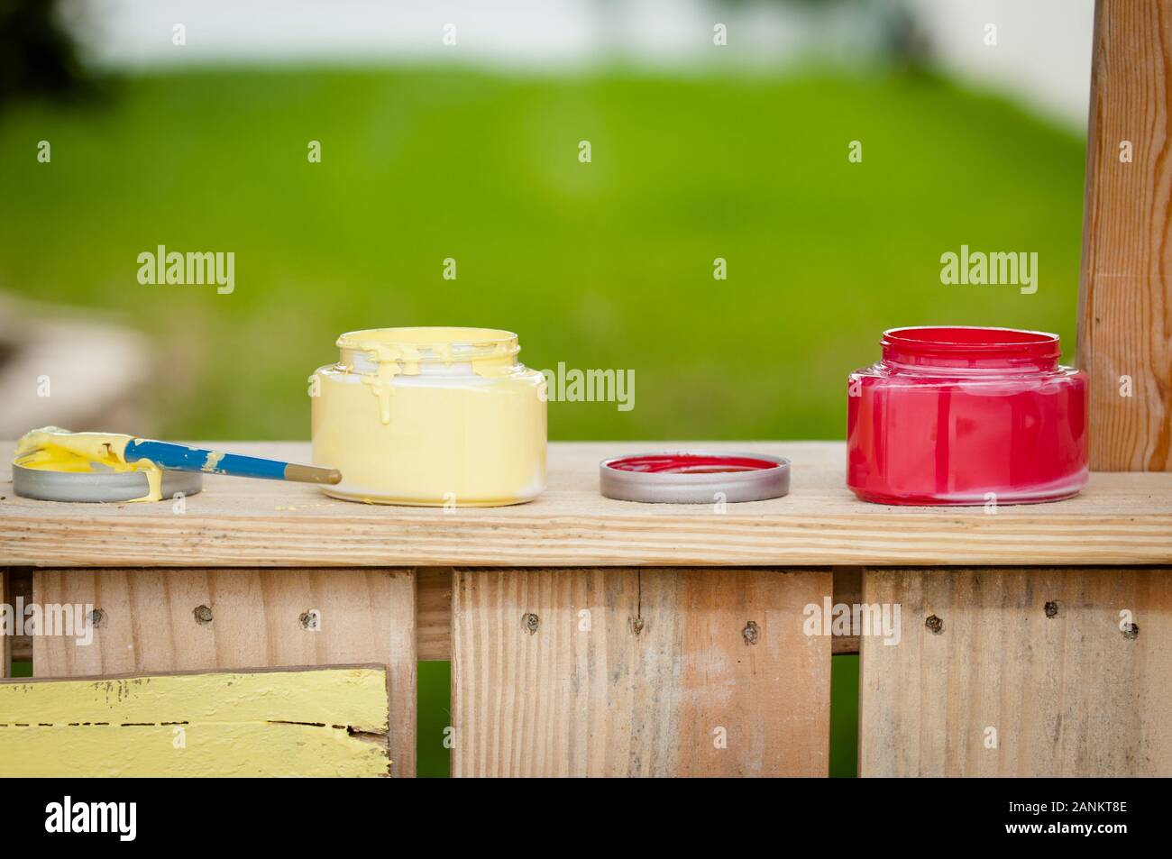 Bottiglie di vernice gialla e rossa sedute su una tribuna di limonata Foto Stock