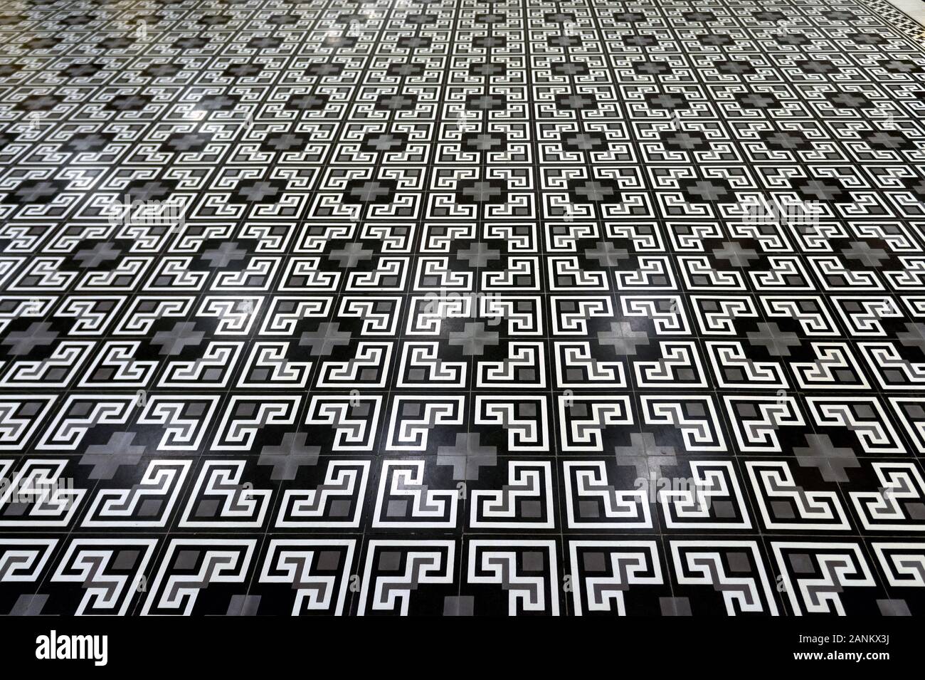 Vintage piastrelle da pavimento. Geometrico ornamento angolare. Retro bianco grigio. Prospettiva. Fotografato in Vietnam presso la stazione della funicolare Foto Stock