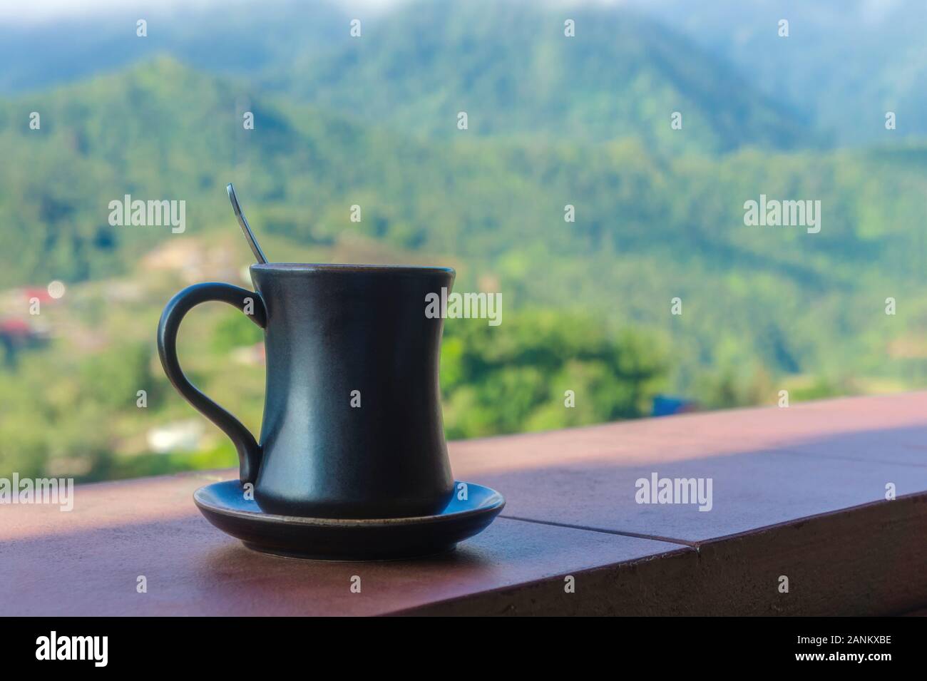 Coppa scuro su un piattino su uno sfondo di montagne tra le nuvole. Sapa, Lao Cai provincia a nord-ovest del Vietnam Foto Stock