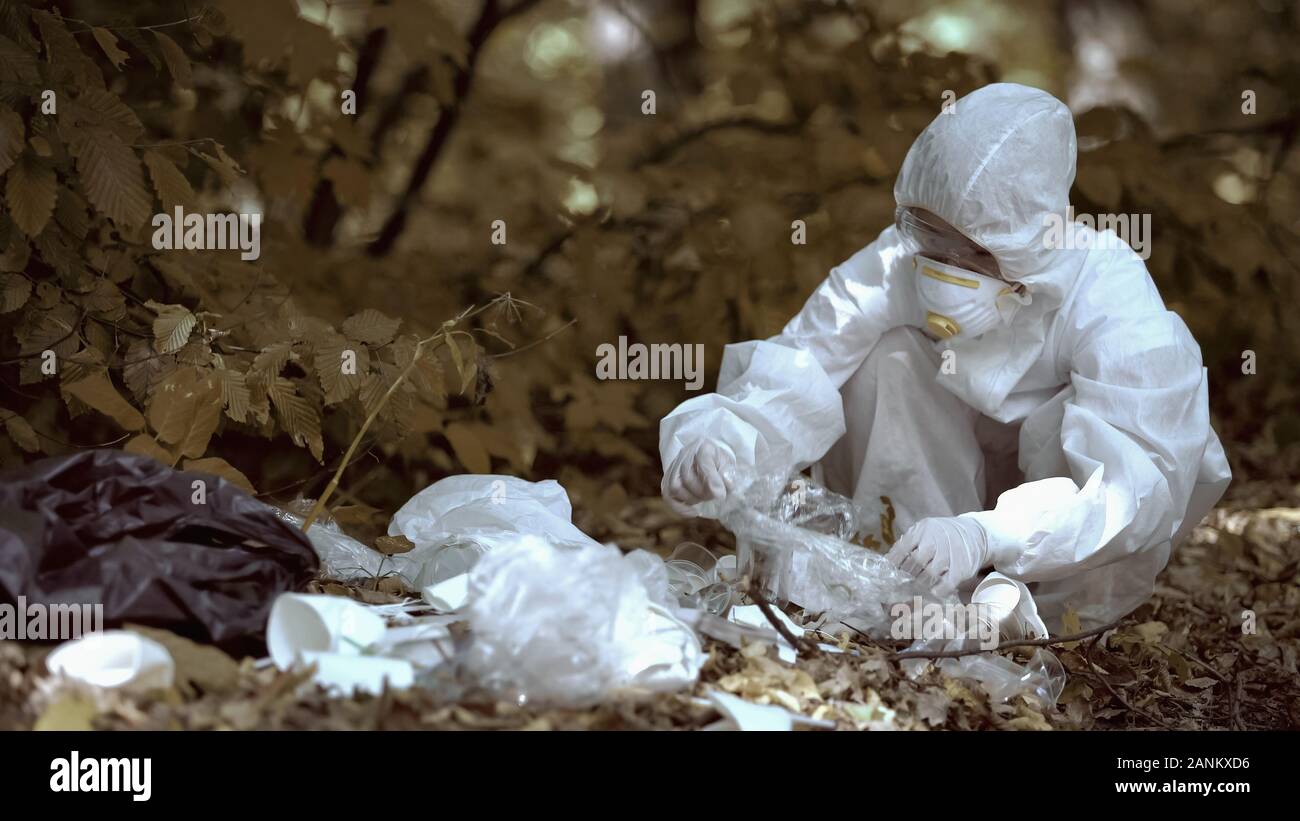 Donna scienziato analizzando garbage in foresta, plastica problema di inquinamento, clima Foto Stock