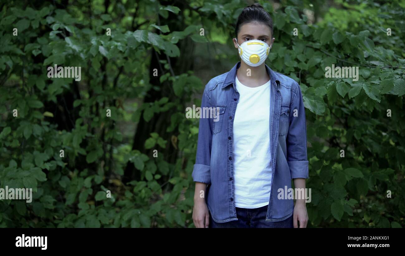 Giovane donna in maschera protettiva, tossici futuro, inquinamento atmosferico, ecologia Foto Stock