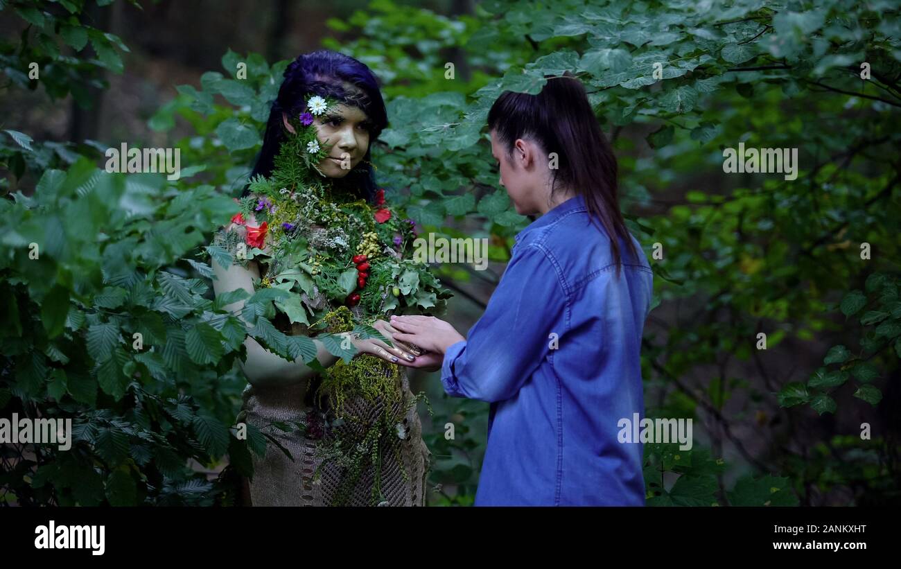 Giovane donna incontro la madre terra nella foresta, natura unità, ambiente sicuro Foto Stock