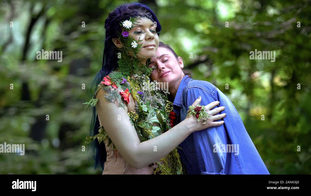 La madre Terra abbracciando giovane donna passeggiate in foresta, in armonia con la natura, cura Foto Stock