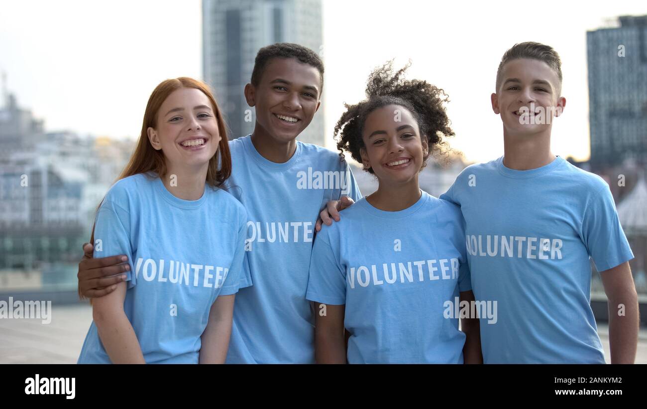 Felice giovani volontario t-shirt che pongono la fotocamera, sociale il lavoro di squadra, aiuto Foto Stock