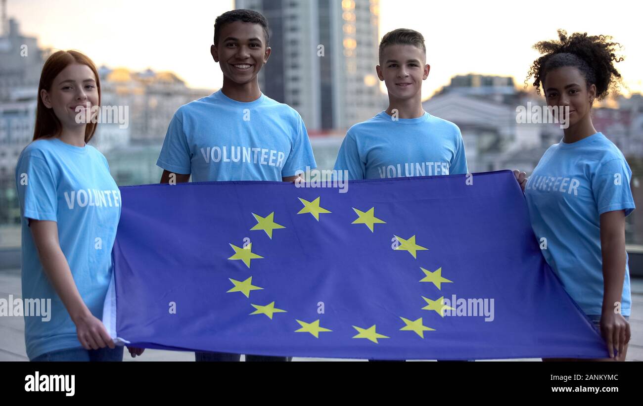 Giovani multi-razziale volontari azienda bandiera dell'Unione europea, l'unità internazionale Foto Stock