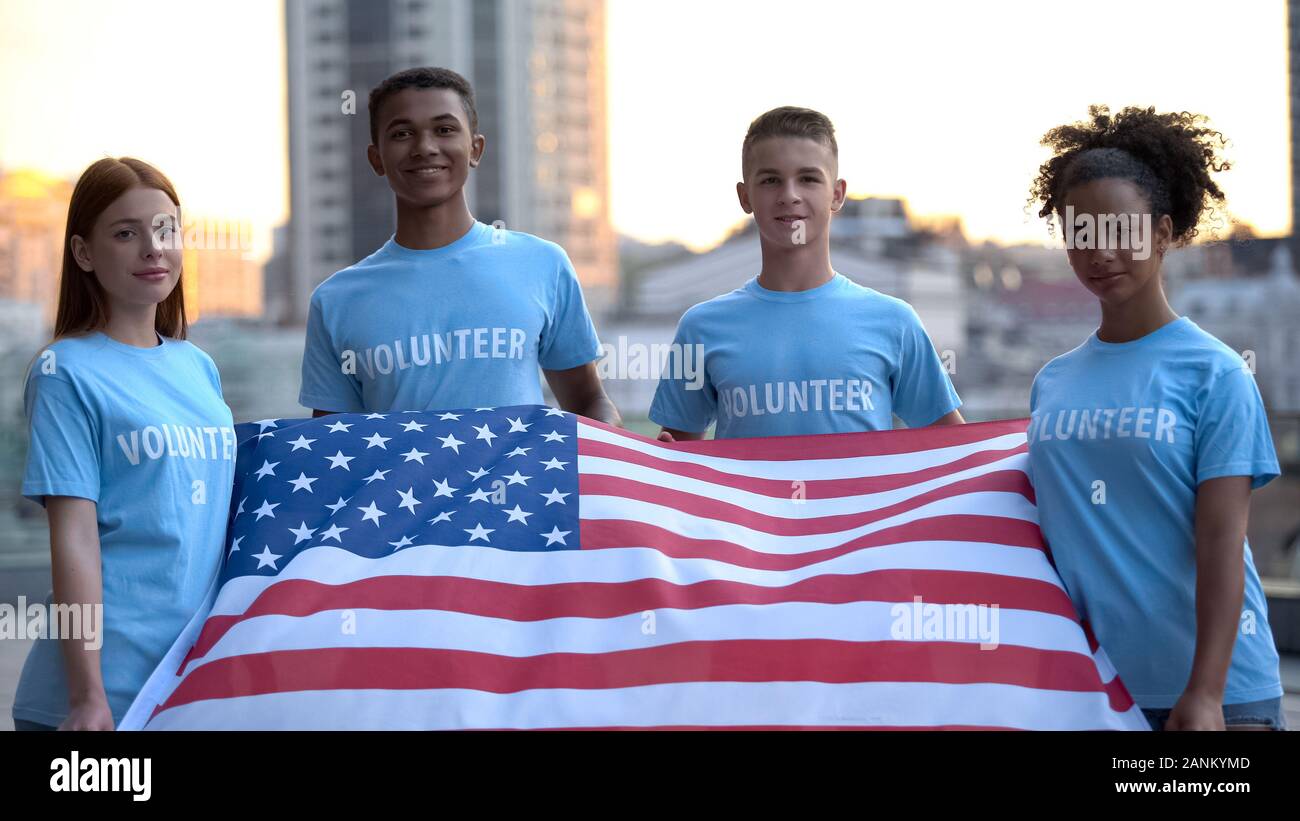 Felice multi-razziale volontari azienda bandiera americana, la fondazione di beneficienza, aiuto Foto Stock