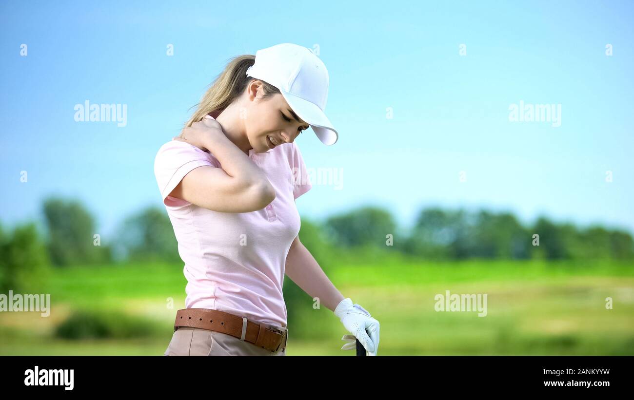 Giovane donna con il club per giocare a golf, sofferenza forte dolore alla spalla, traumi sportivi Foto Stock