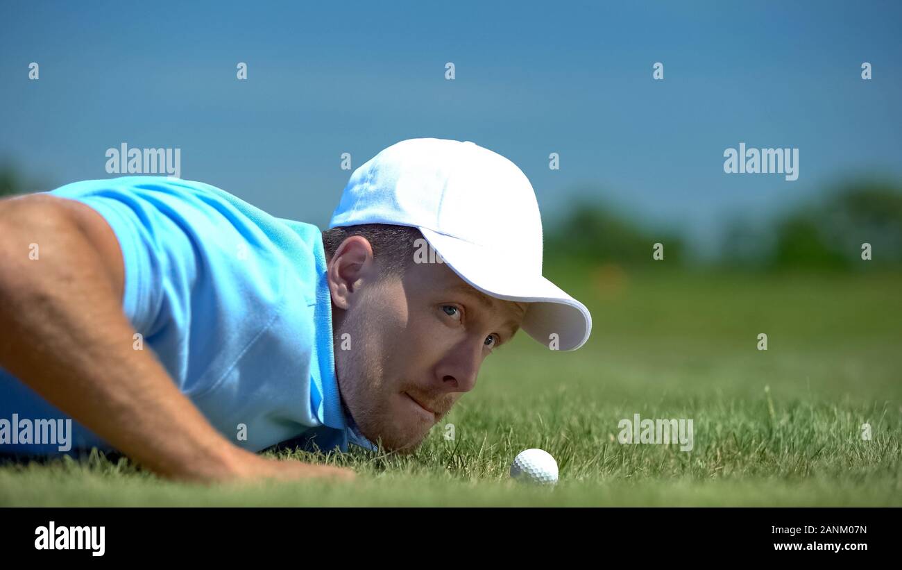 Tricky uomo soffiando la pallina da golf nel foro, agilità e astuta strategia di successo hobby Foto Stock