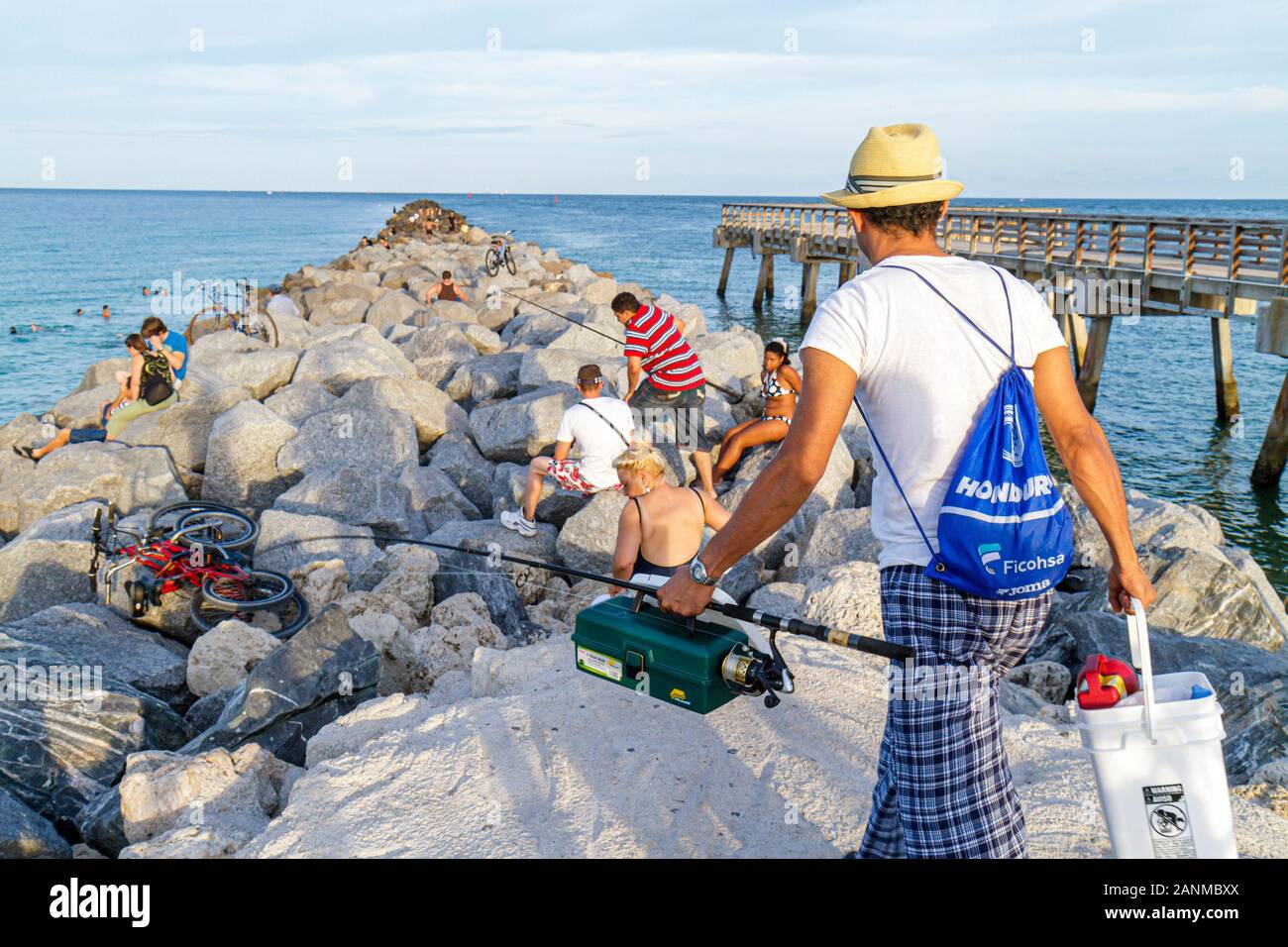 Miami Beach Florida,Oceano Atlantico,acqua,molo,frangiflutti,rocce,pesca in corso,uomo ispanico maschio,FL100815007 Foto Stock