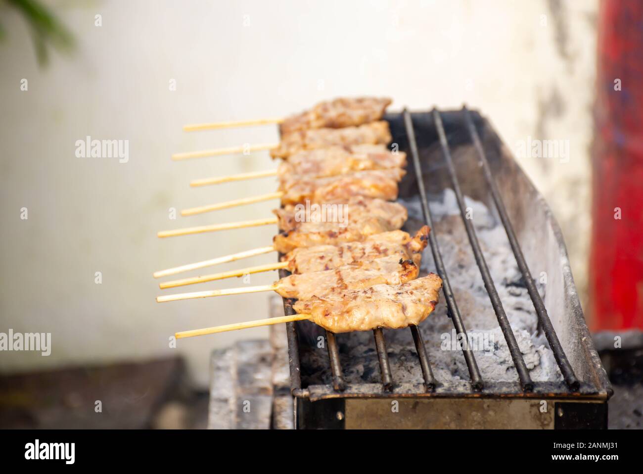 Grigliata di carne di maiale marinato con salsa di Spiedini e piccolo sulle griglie di acciaio con il calore. Foto Stock