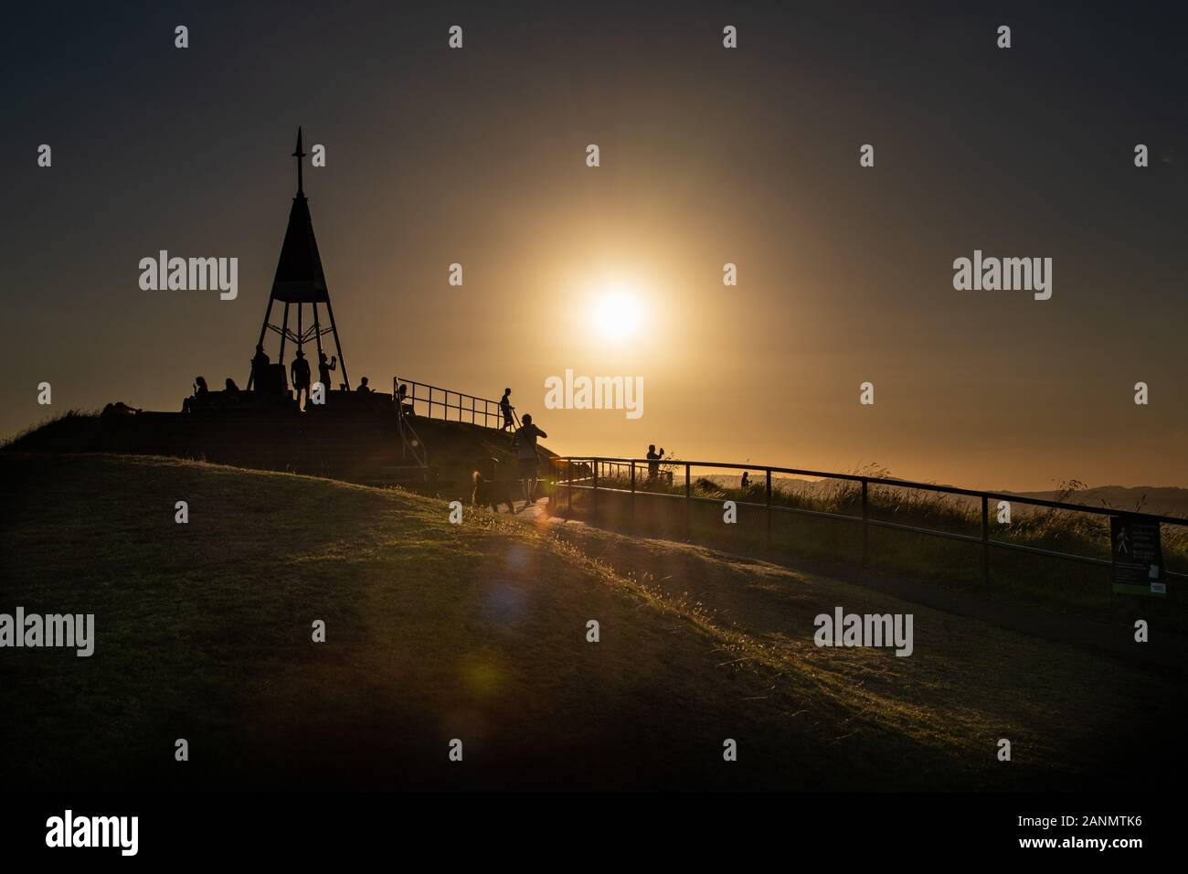 Silhouette di persone a guardare il tramonto sulla sommità del monte Eden, Auckland Foto Stock