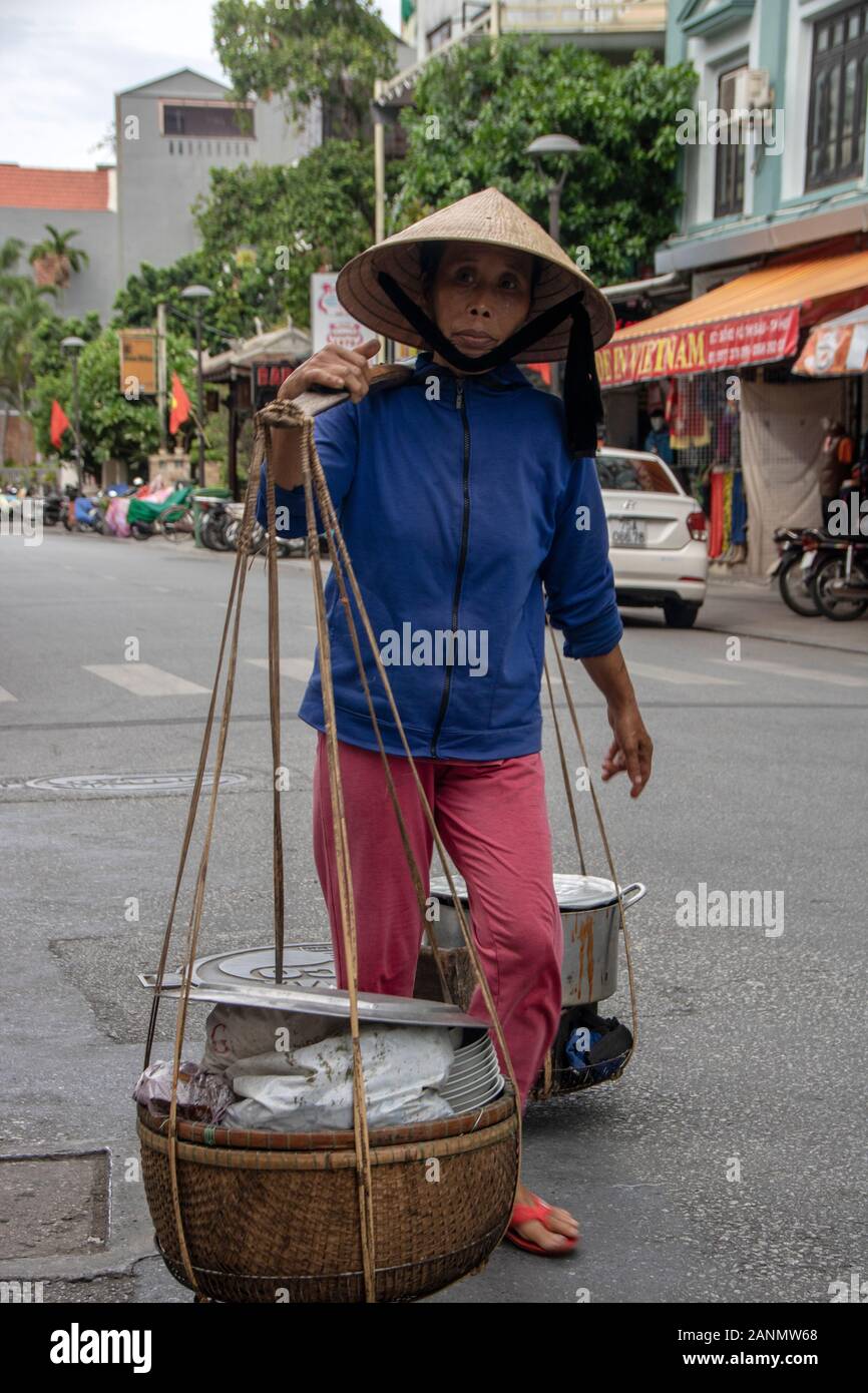 A Hue - Vietnam - agosto 2019 - donna che trasportano merci sulla sua spalla Foto Stock