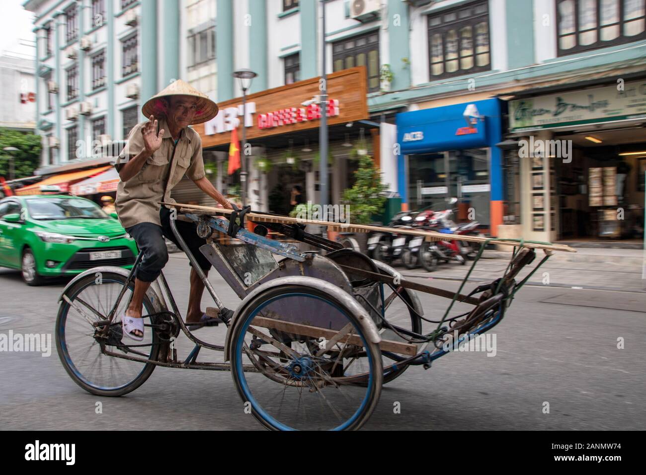 A Hue - Vietnam - agosto 2019 - uomo alla guida di un rickshaw nella città vecchia Foto Stock