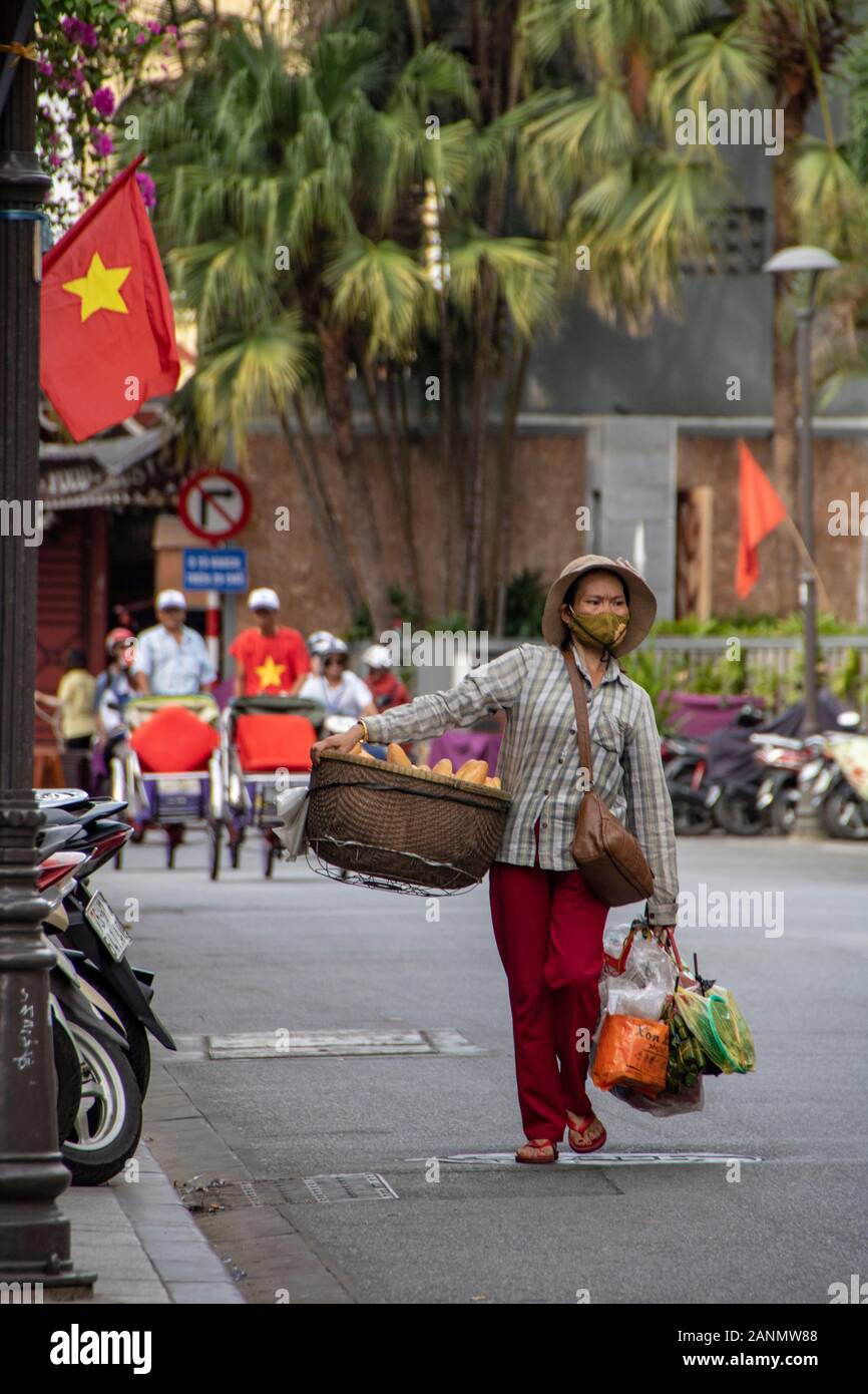 A Hue - Vietnam - agosto 2019 - donna che trasportano merci sulla sua spalla Foto Stock