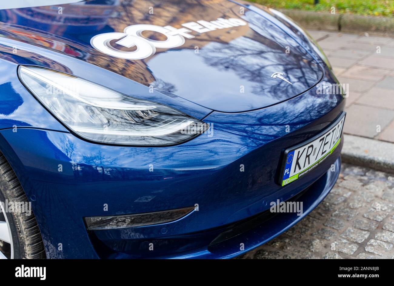 Vista frontale di Tesla Model 3 parcheggiata a noleggio. Società di noleggio auto elettriche a Cracovia. Bel colore blu classico. Solo editoriale. Foto Stock