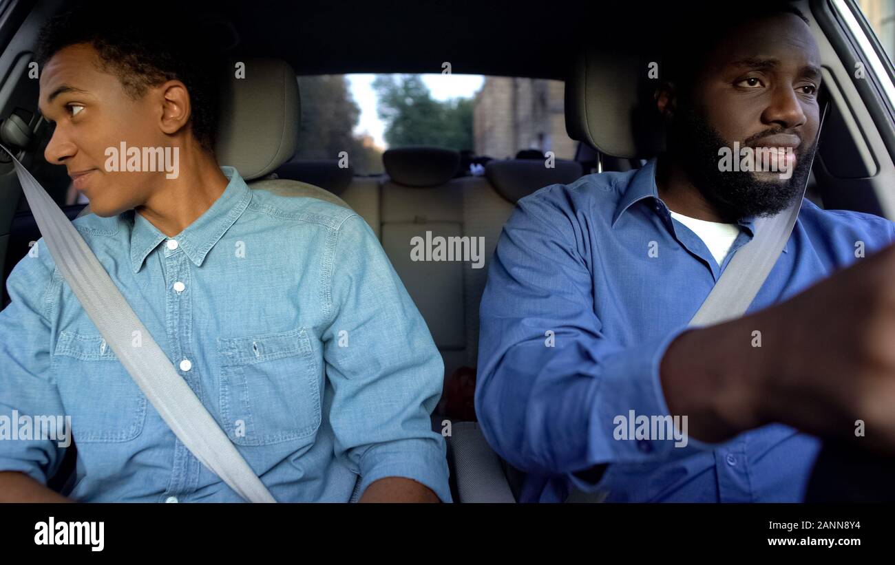Padre e figlio la guida in automobile, ragazzo cerca nella finestra, malinteso Foto Stock