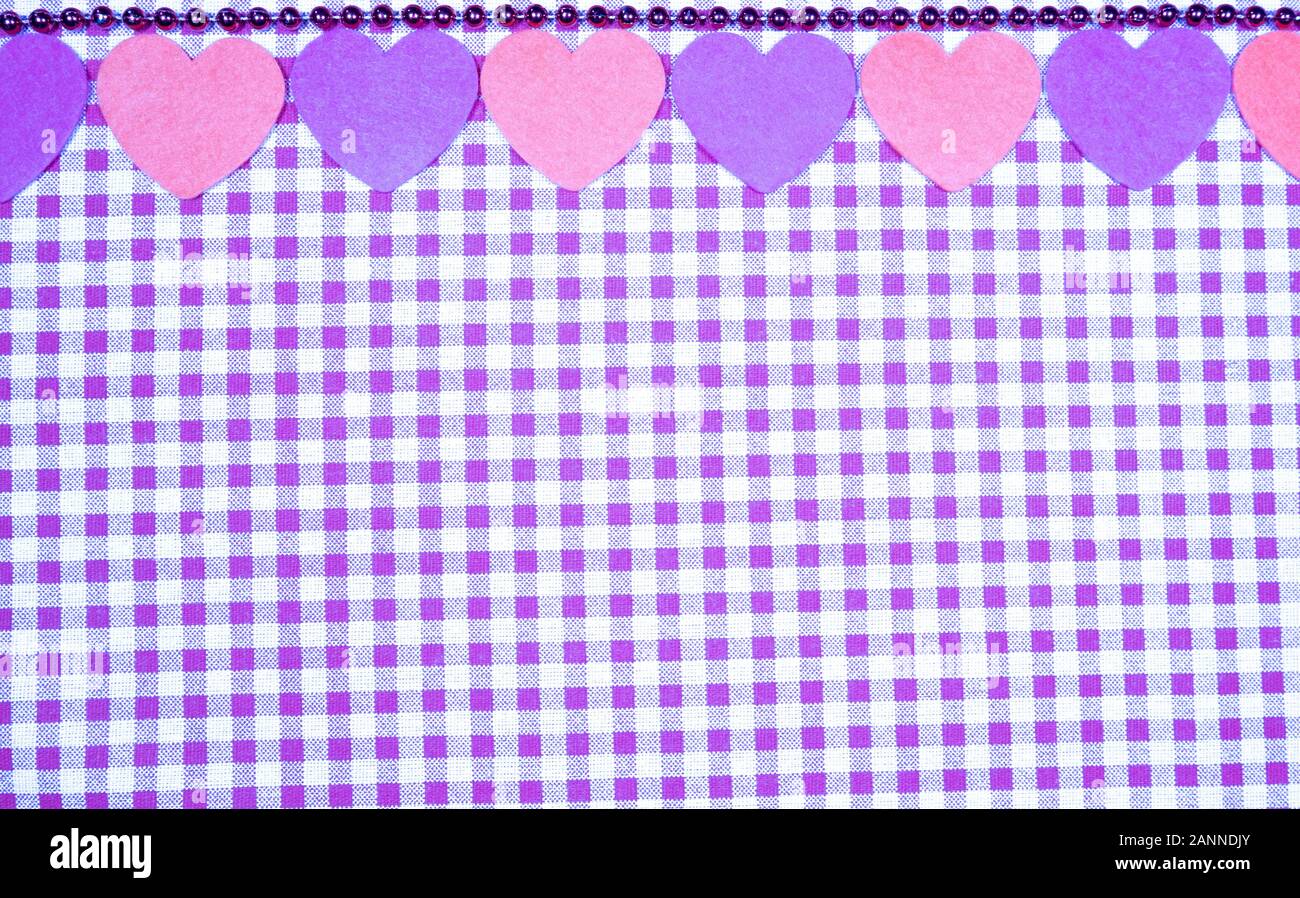 Sfondo con viola e bianco tessuto Vichy per il giorno di San Valentino con rosa e viola cuori. Il giorno di San Valentino del concetto. Foto Stock