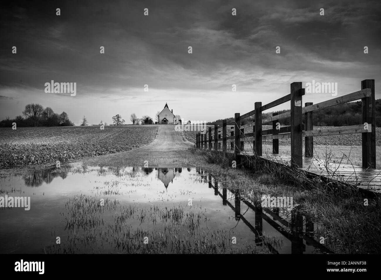 St Huberts Cappella in Idsworth Hampshire che riflette in acqua dopo la pioggia, una tipica vecchia chiesa inglese Foto Stock